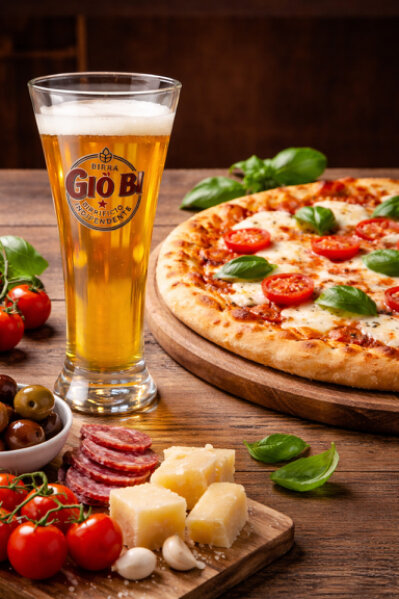 Bicchiere di birra chiara artigianale Gio’Bi Lager su tavolo in legno